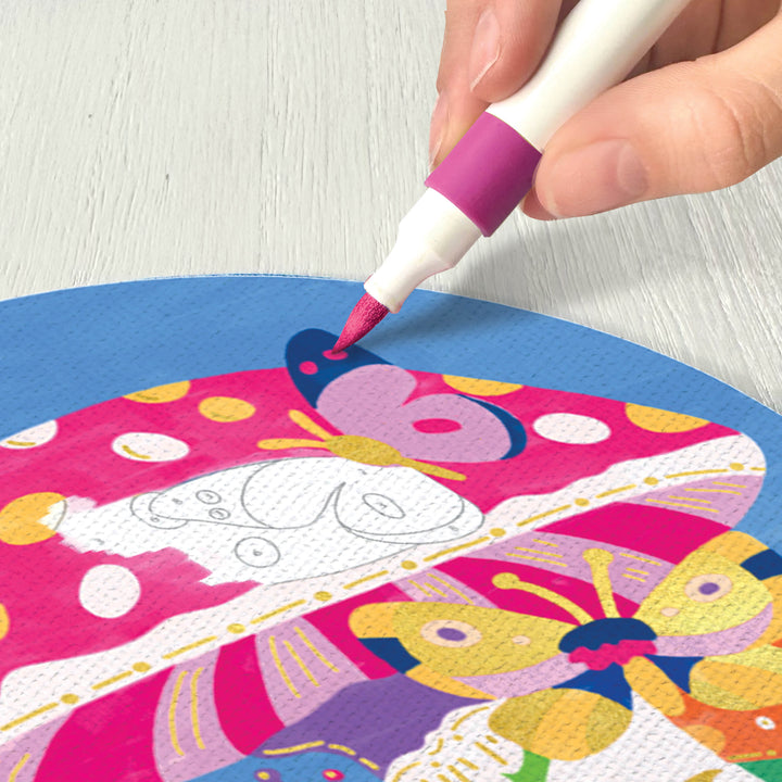 A person using the pink marker to fill in the canvas. 